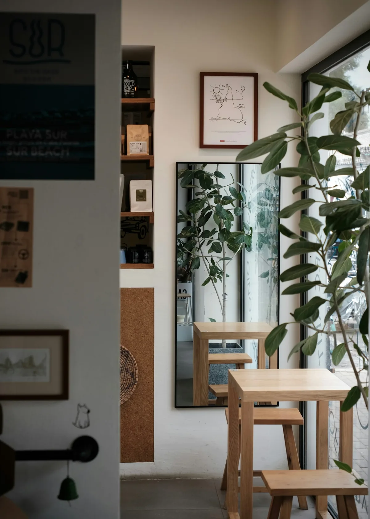A café table beside a window and green plants